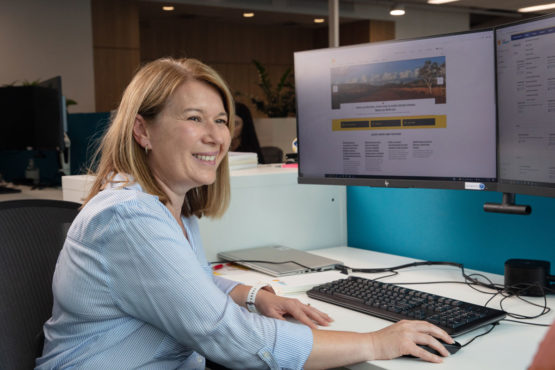 A smiling Powermetric team member at their computer
